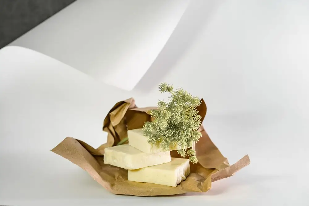 Lyse såpestykker pakket i papir med tørkede planter